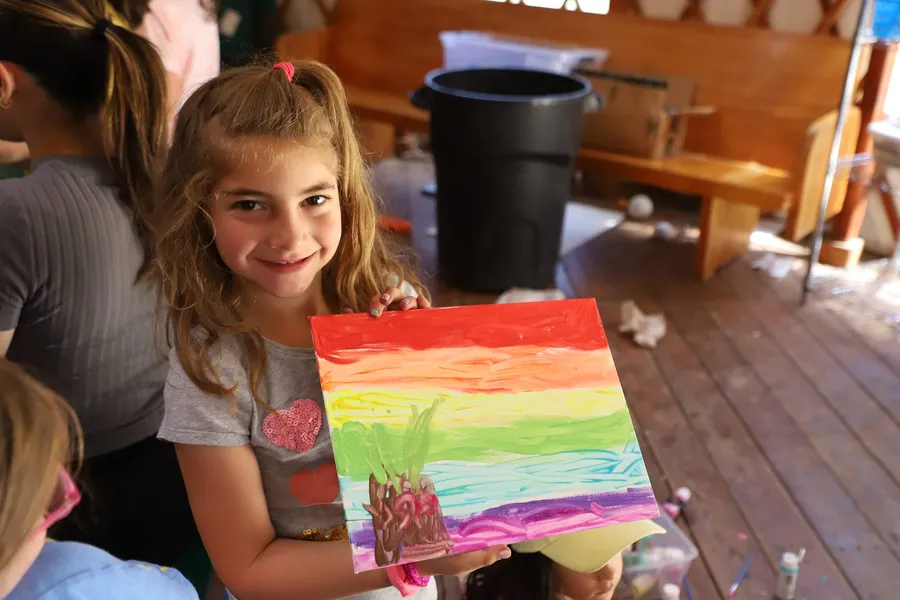 Camper holding a painting during arts and crafts